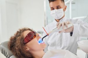 a lady is getting teeth whitening treatment