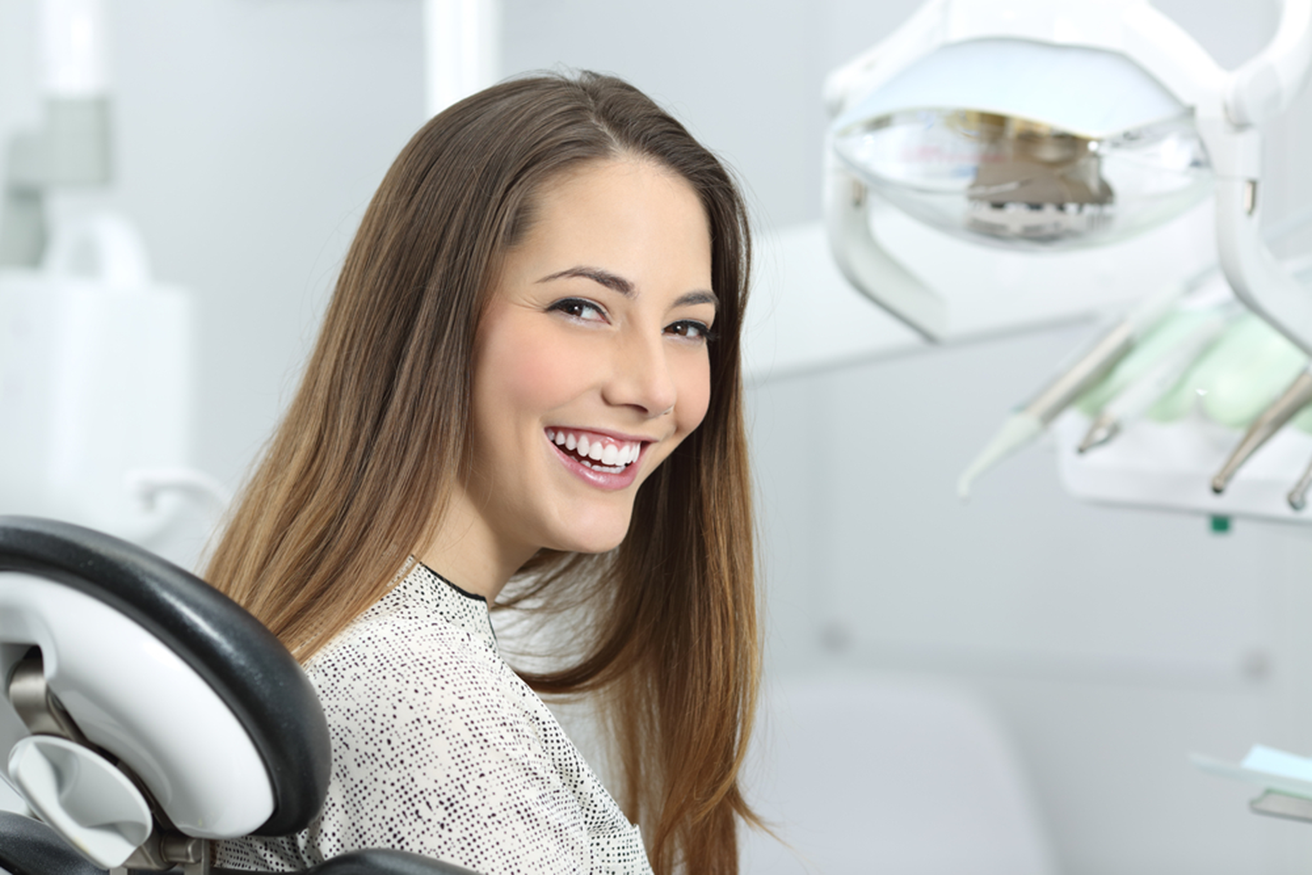 a lady is smiling after having dental treatment