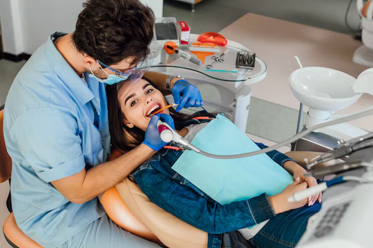 a dentist is checking a lady's teeth