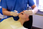 a woman is having periodontal treatment from a dentist