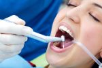a lady is having root canal treatment because of tooth pain
